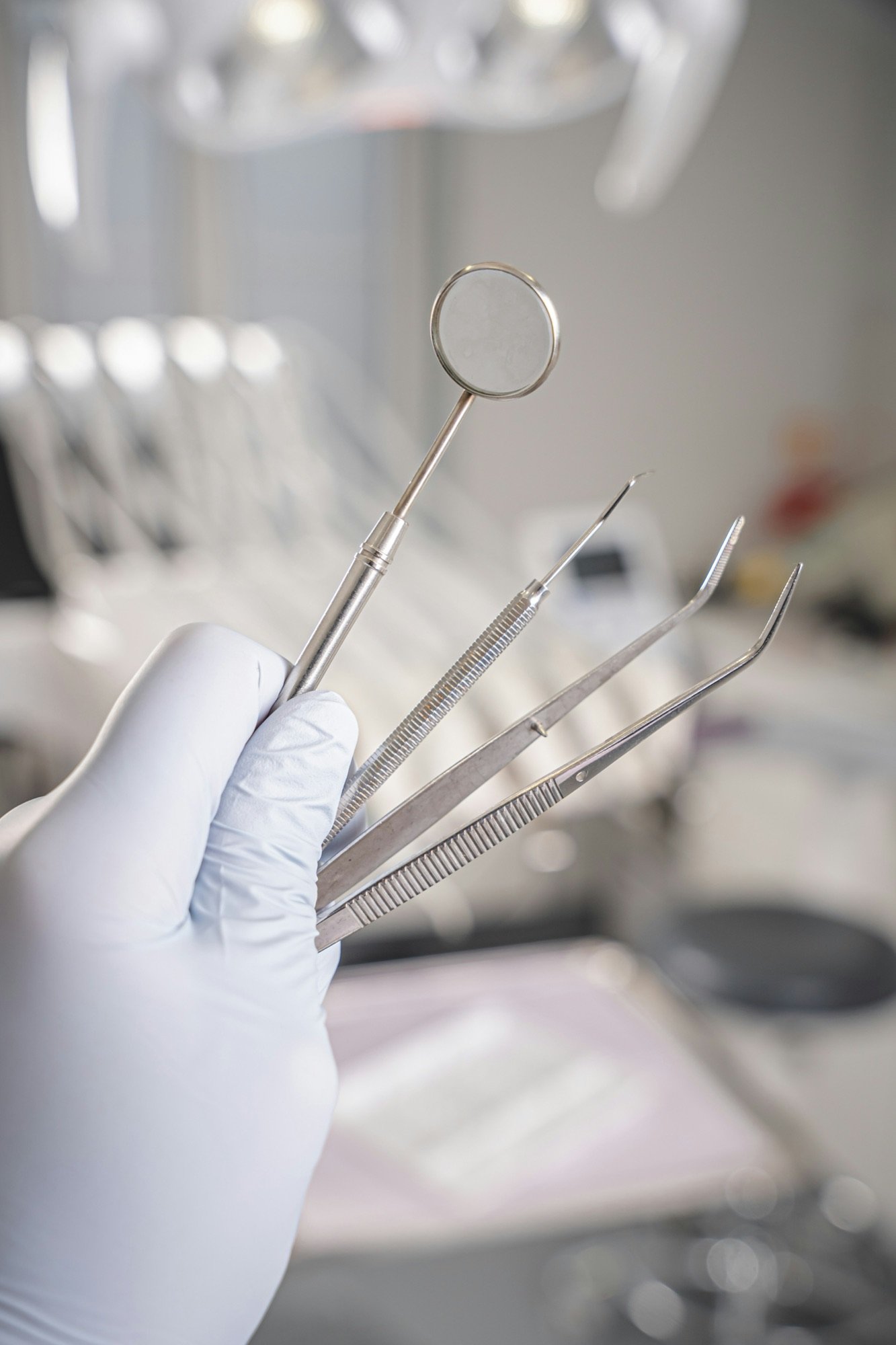 Dental examination instruments in a gloved hand