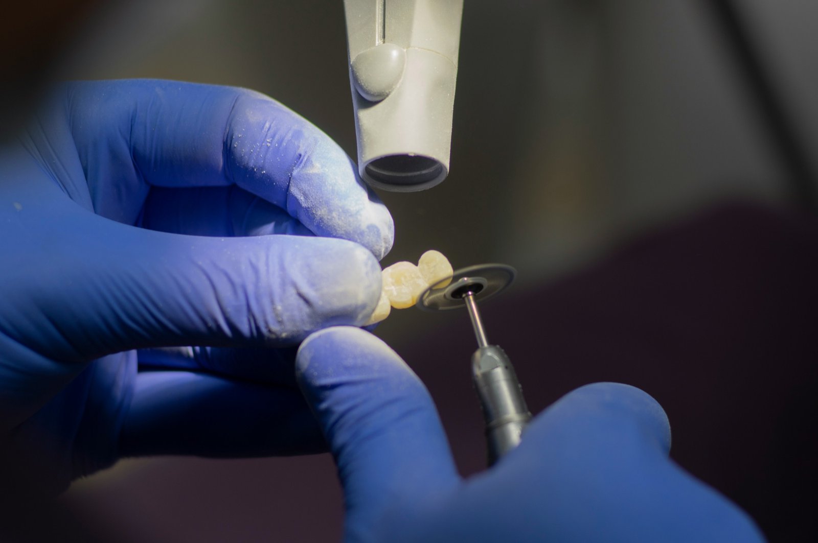Dental crown being finished by hand